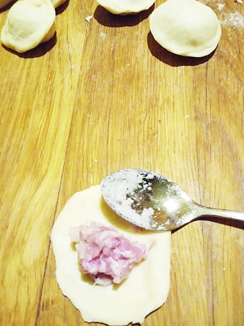 ◆ Ar tējkaroti mīklas aplīša vidū ieliek pildījumu. Aplīti pārloka uz pusēm un malas salipina kopā: iznāks pīrādziņš. Pelmeņus var atstāt gan tādā formā, gan galus salipināt kopā. Gatavos pelmeņus sarindo uz pamatnes, kas pārkaisīta ar miltiem.
Autors: Liene Andersone-Kolosova
